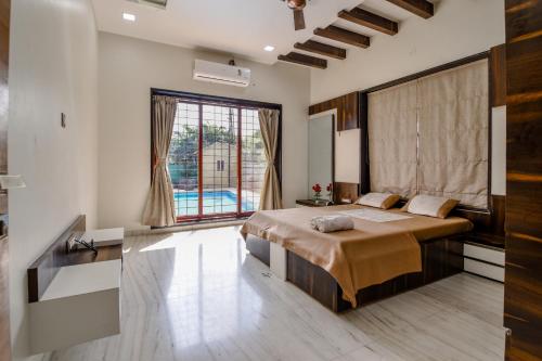 罗纳瓦拉Villan Villa Luxurious Mountain View Biggest Pool的一间卧室设有一张床和一个大窗户