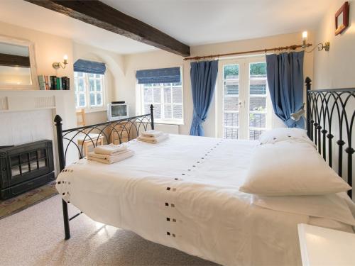 纳尔斯伯勒4 bed property in Knaresborough HH090的卧室配有一张白色大床和壁炉