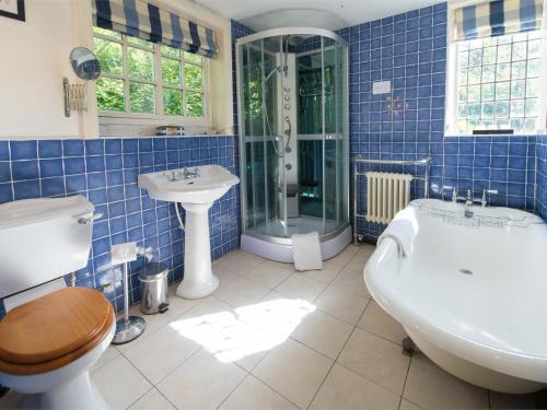 纳尔斯伯勒4 bed property in Knaresborough HH090的蓝色瓷砖浴室设有浴缸和水槽