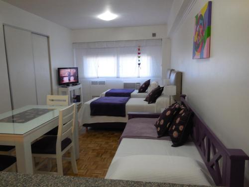 布宜诺斯艾利斯米克罗中央公寓的一间卧室配有两张床、一张桌子和一张桌子