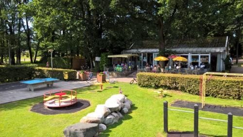 奥特马瑟姆Camping de Haer的一个带游乐场的公园,配有游戏设备