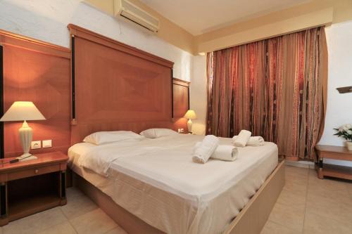 ParánimfoiTris Ekklisies Beachfront Apartment - Ammos的一间卧室配有一张大床和两条毛巾
