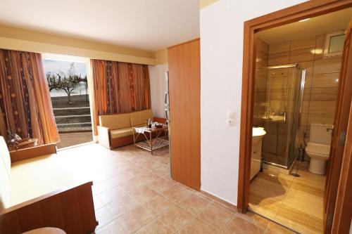 ParánimfoiTris Ekklisies Beachfront Apartment - Ammos的带淋浴、卫生间和盥洗盆的浴室