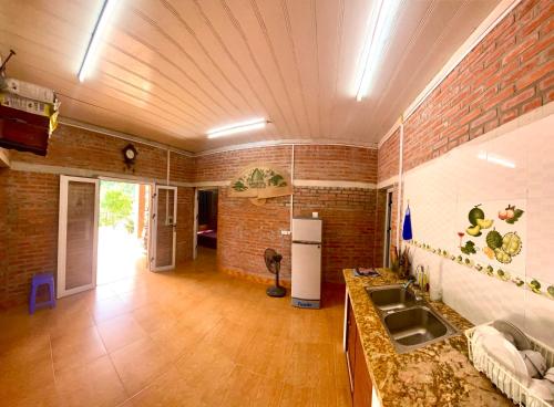 河内Lều biệt thự的厨房设有水槽和砖墙