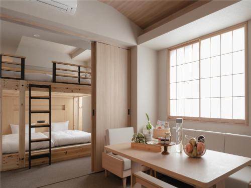 东京MIMARU SUITES Tokyo NIHOMBASHI的客房设有一张桌子和一张双层床。