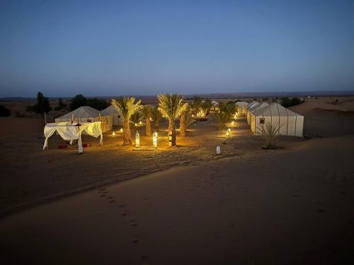 AdrouineNomads Luxury Camp Merzouga的一群夜晚在沙漠中的帐篷