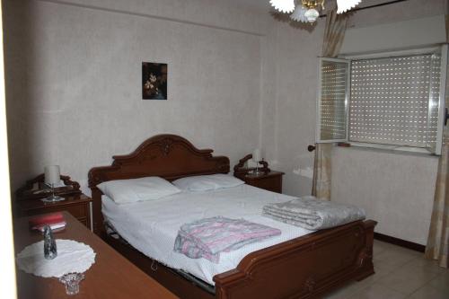 贾迪尼-纳克索斯Grazioso appartamento vicino al mare的一间卧室配有一张床、一张桌子和一个窗户。