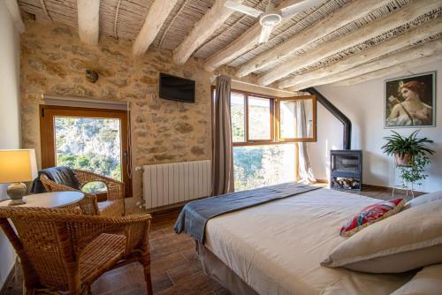 PatróCasa rural Vall de Gallinera con Chimenea, piscina y jacuzzi DIANIA的一间卧室配有一张大床和一张桌子及椅子