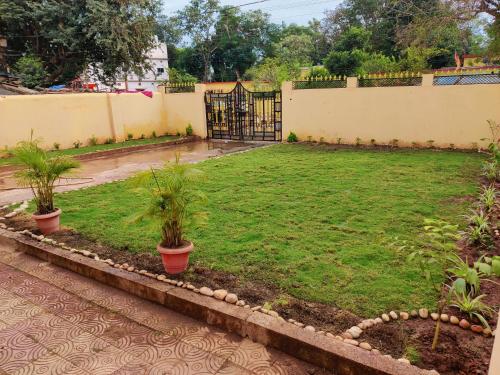 JagdalpurSangeeta's Homestay的两盆植物和围栏的院子