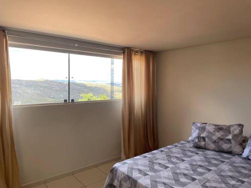 迪亚曼蒂纳Residencial Vista da Serra的一间卧室设有一张床和一个大窗户