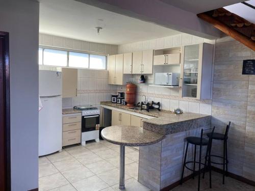 迪亚曼蒂纳Residencial Vista da Serra的厨房配有白色家电和桌椅