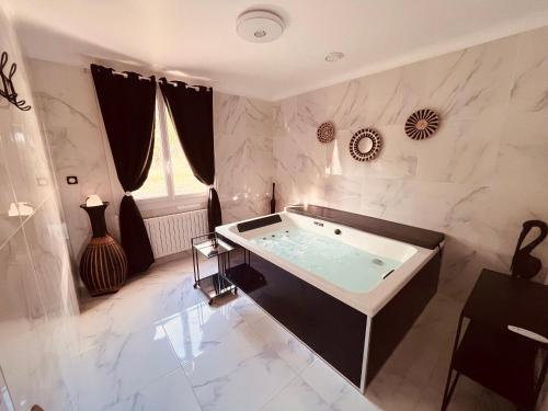 朗贝斯克Domaine Amourella的一间带按摩浴缸的大浴室