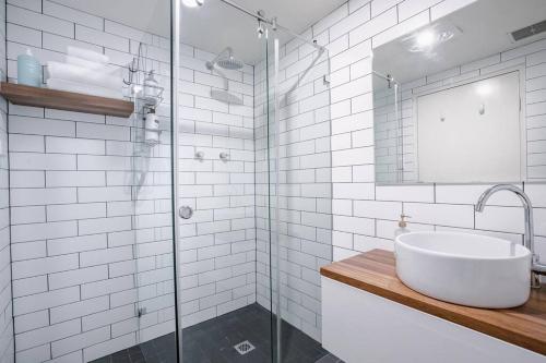 悉尼Crows Nest Gem - with parking的一间带水槽和玻璃淋浴的浴室