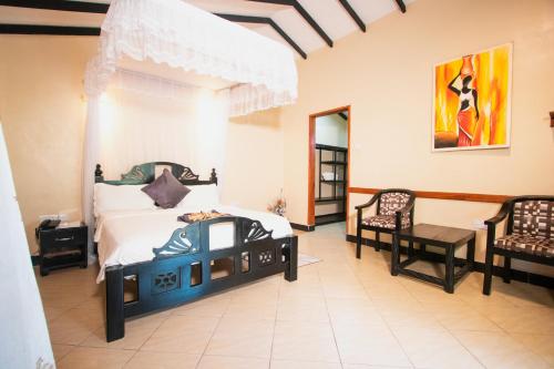 达累斯萨拉姆客及及海滩度假酒店的一间卧室配有一张床和两把椅子
