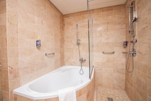 德布勒森里西姆德布勒森酒店的设有带浴缸和淋浴的浴室。