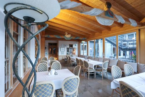 马克特奥伯多夫Arthotel Ana Panorama的餐厅设有桌椅和窗户。