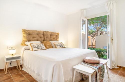 松霍里吉尔Menorca Paradise nº 30的卧室设有白色的床和大窗户