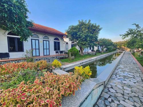 宁平Hoa Lu Garden Resort的房屋前有运河的房子