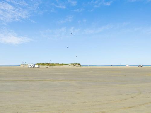 拉科克Apartment Gunnlaug - 500m from the sea in Western Jutland by Interhome的风筝在沙滩上飞行的人