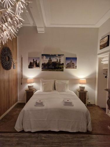 马斯特里赫特Klooster Mariadal Maastricht的一间卧室配有一张带两盏灯的大型白色床。