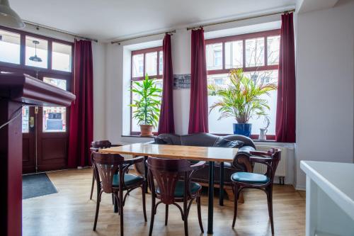 柏林Alt-Berliner Eckkneipe - "Feuchte Ecke"的一间设有红色窗帘和桌椅的用餐室