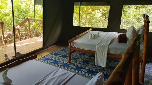 KwangwaziCamp Seluu - Safari Pkg的一个带门廊的帐篷内一间卧室,配有一张床