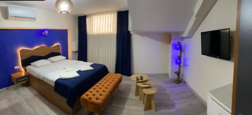 伊斯坦布尔Kadıköy Linda Hotel的一间卧室配有蓝色的床和电视