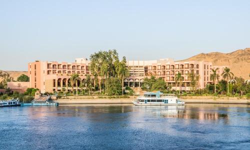 阿斯旺Pyramisa Island Hotel Aswan的大型建筑前的水中小船