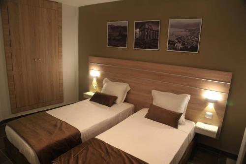 突尼斯MONDIAL HOTEL的配有灯的酒店客房内的两张床