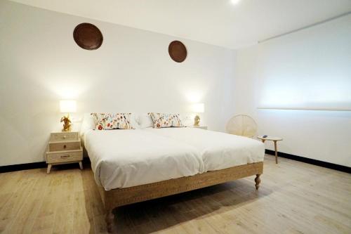 图伊La SIGRINA Tuy的一间卧室配有带白色床单和枕头的床。