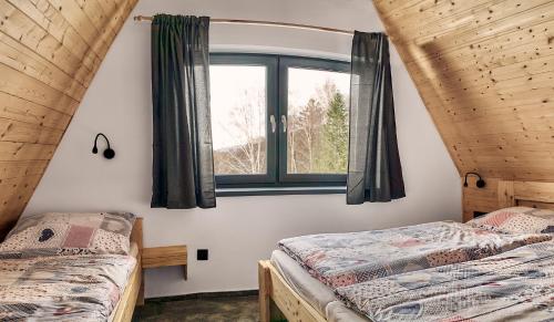 利波瓦拉尼Resort Bobrovník的带窗户的客房内的两张床