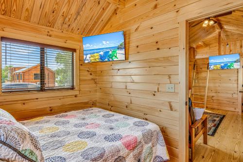马拉松Cabins at Bonefish Bay的小屋卧室配有1张床和2台电视