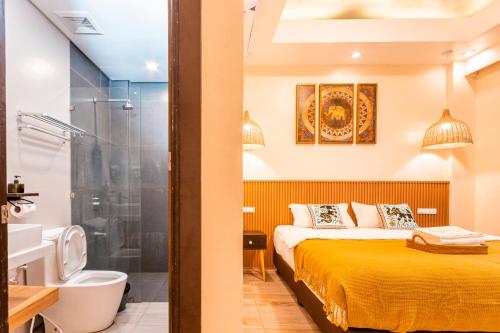 波尔多·格尼拉茉莉酒店的一间卧室配有一张床和淋浴,还有一间浴室