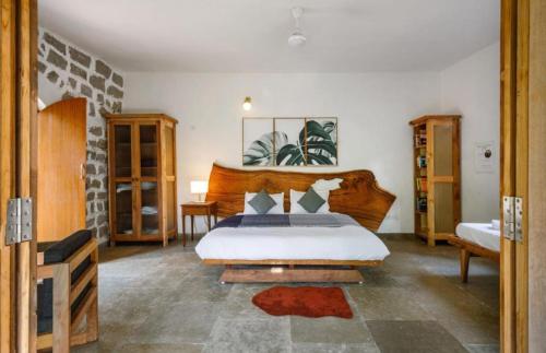 SanivÄrsanteJungle stay by Bilwa Estate的一间卧室配有一张带木制床头板的床
