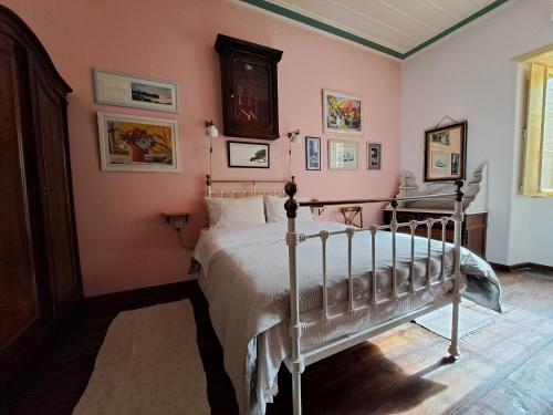 伊兹拉Rafalias Mansion的卧室配有一张床铺,位于一间粉红色墙壁的房间