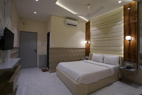 孟买Palm Springs Beach Resort - Gorai的卧室配有一张白色大床和电视。