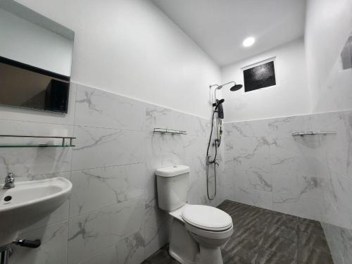 TuaranRestu Villa Homestay的白色的浴室设有卫生间和水槽。