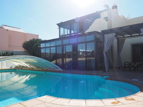 特吉塞Luxury Canarian villa with large pool and apartment in Costa Teguise的房屋前有游泳池的房子
