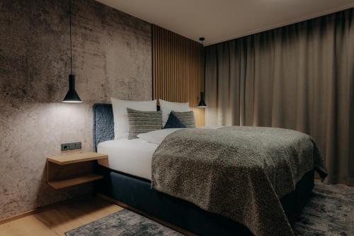 卡顿巴赫Appartement Auszeit KERSCHDORFER的一间卧室设有一张大床和混凝土墙