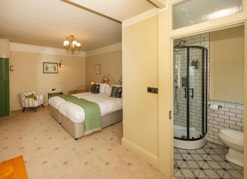 布里德波特艾琵村口乡村酒店的一间卧室配有一张床,浴室设有淋浴。