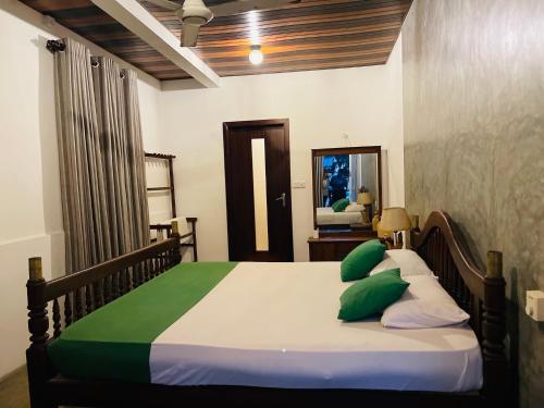 希克杜沃New Amadeo Beach的一间卧室配有带绿色和白色枕头的床