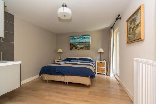 雷讷瑟Zoomgronden Renesse的一间卧室配有一张带蓝色毯子的床