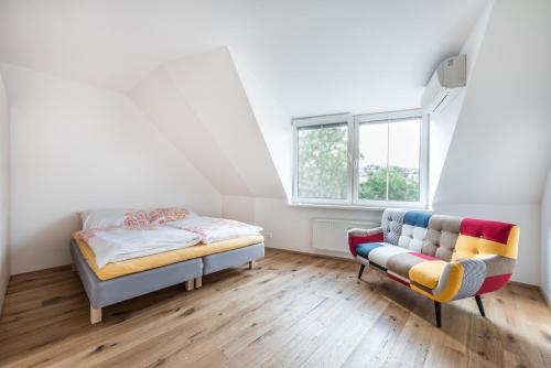 布拉迪斯拉发城堡墙公寓的一间卧室配有一张床、一张沙发和一个窗口
