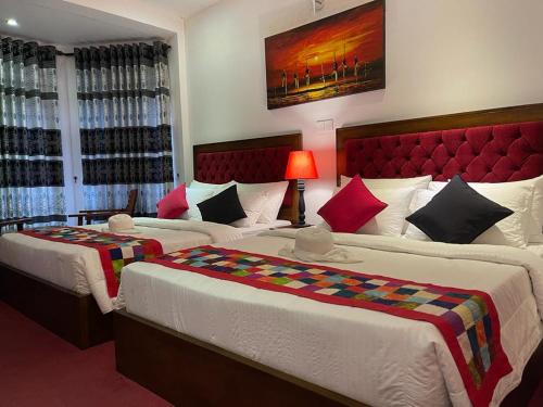 努沃勒埃利耶The Rosedale Grand Bungalow Nuwara Eliya的一间卧室设有两张床和红色床头板
