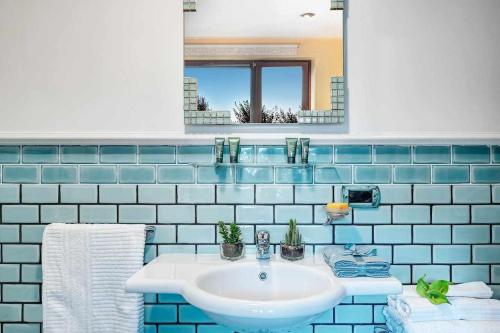 马萨鲁布朗斯Villa Islamorada Pool and Sea View的蓝色瓷砖浴室设有水槽和镜子