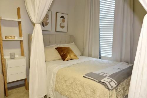 洛杉矶MDR Studio Apartment Luxury pool, gym, parking, jacuzzi.的一间小卧室,配有一张带窗帘的床