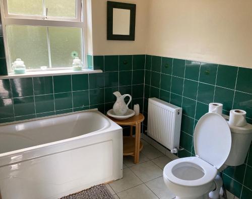 格伦科伦基尔Glencolumbkille House - Self Catering Rooms的带浴缸、卫生间和盥洗盆的浴室