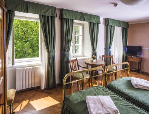 布拉格布拉格罗马酒店的一间卧室设有两张床、一张桌子和一个窗口