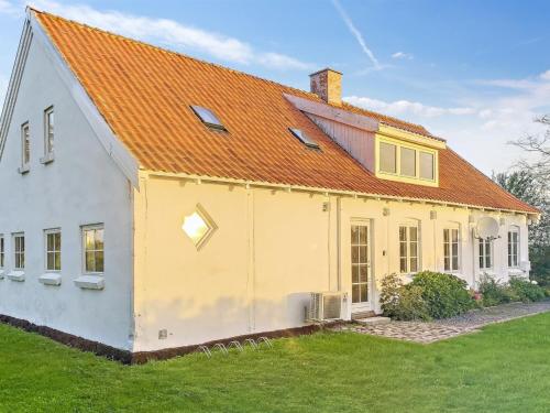 古兹耶姆Holiday Home Torbjörn - 2-5km from the sea in Bornholm by Interhome的黄色和白色的房子,有橙色的屋顶