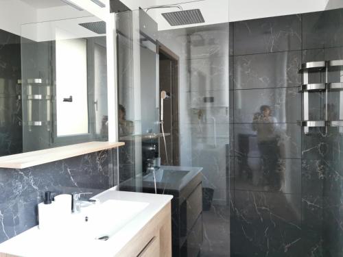 佩皮尼昂Appart Hotel Cinéma Perpignan的带淋浴、盥洗盆和镜子的浴室